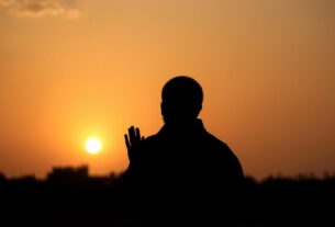 Pessoa orando ao amanhecer, demonstrando sinais de prioridade espiritual em sua rotina diária